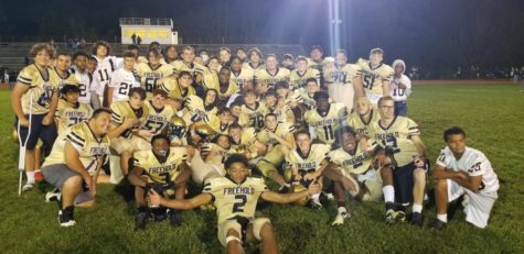 The Freehold Colonials huddle together after their victorious win against  their cross-town rivals, the Township Patriots